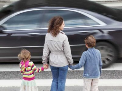 mamma med barn v&auml;ntar vid &ouml;verg&aring;ngsst&auml;lle