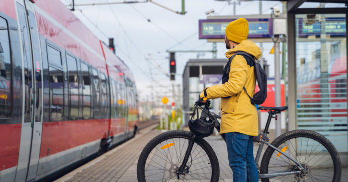 Man med cykel st&aring;r p&aring; perrong och v&auml;ntar p&aring; att t&aring;gens d&ouml;rrar ska &ouml;ppnas och han kan g&aring; p&aring;.