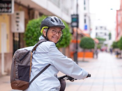 senior dam med ryggs&auml;ck cyklar i stan