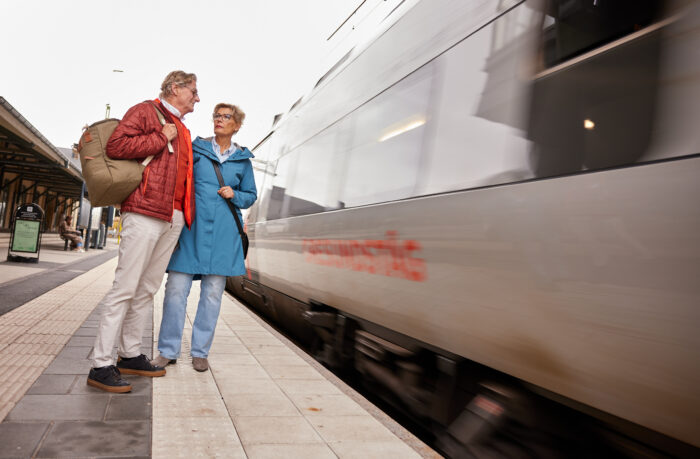 ett par v&auml;ntar p&aring; perrongen n&auml;r ett t&aring;g passerar